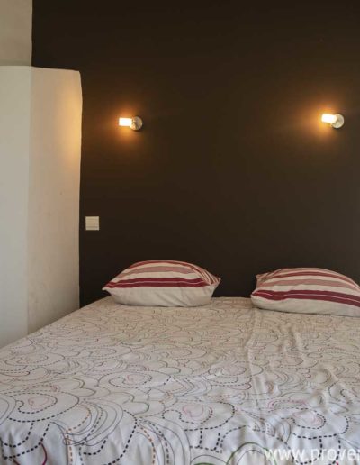 La chambre au premier étage avec sont lit double en 140 cm et ses tons sobres propices à la détente pour des vacances reposantes dans la location Les Gavottes au Revest des Brousses au coeur de la Provence.