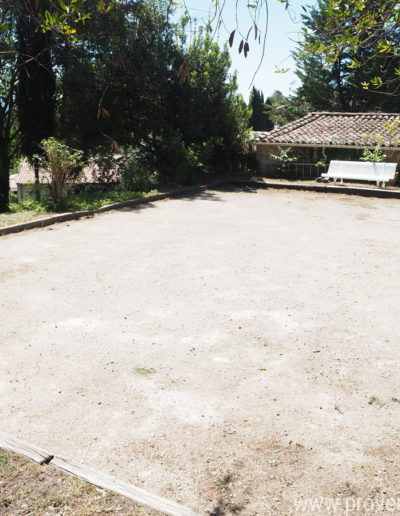 Le terrain de boules baigné de lumière et entouré d'une belle végétation foisonnante, pour un décor nature dans la location de vacances Le Castellas située à Manosque dans le Luberon.