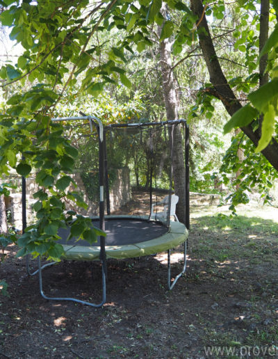 Le trampoline à l'ombre des grands arbres du parcs de la location de vacances Le Castellas à Manosque au cœur du Luberon.