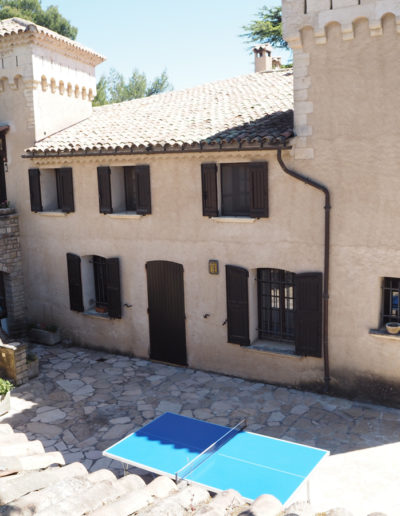 Vue sur la façade principale avec son escalier accédant au premier étage réservé aux locations. La maison avec ses tours de part et d'autres s'élève vers le ciel bleu de Manosque telle un château entouré de son parc verdoyant pour des vacances sous le signe de la détente dans la maison Le Castellas au cœur de la Provence;