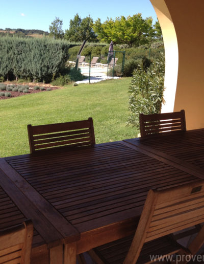 Les alcôves de la terrasse couverte qui laissent entrevoir la nature environnante et verdoyante du jardin de la location de vacances Les Lavandins située à Lurs, en Provence.