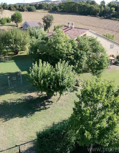 Le jardin du domaine de la Tuilière, arboré et verdoyant avec ses deux maisons entouré par les champs pour des vacances reposantes au coeur de la Provence à Lurs.