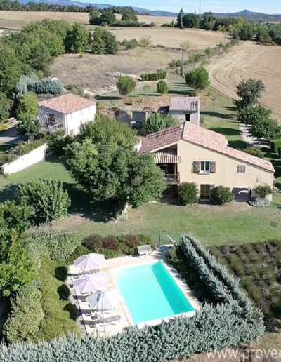 Vue aérienne du Domaine La tuilière, avec la piscine des lavandins au premier plan, les deux maisons et son jardin paysagé verdoyant entouré de champs et les montagnes à l'horizon. Des vacances au grand air dans notre location située à Lurs au cœur de la Provence.
