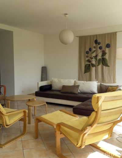 L'espace salon lumineux avec son grand canapé confortable et ses fauteuils ergonomique pour un séjour agréable dans la location de vacances Le Fontauris située au cœur de Forcalquier en Provence.