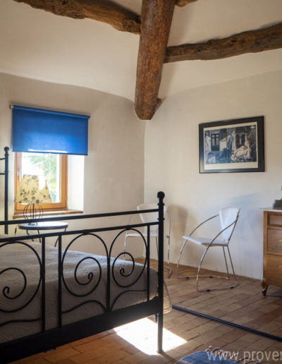 La chambre du deuxième étage mélange authenticité et modernité avec son cabinet en bois et son lit double en fer forgé une combinaison réussi révélant le confort et la chaleur de la location de vacances La Norgère au cœur de la Provence à Mane.