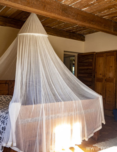 Le plafond à la française, les façades de placard en bois et les touches de couleur allient charme et chaleur dans la chambre double du premier étage du gîte de vacances La Norgère situé dans le village historique de Mane au cœur de la Provence