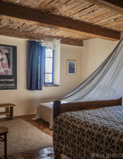 La chambre au premier étage avec ses beaux volumes et le charme du plafond à la française et ses poutres apparentes donnant toute son authenticité à la location de vacances La Norgère à Mane en Provence.