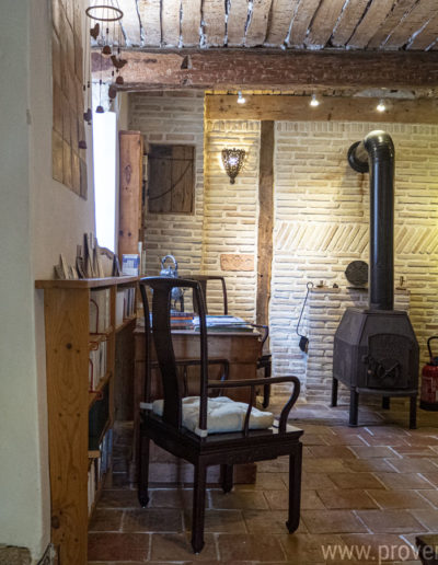 Authenticité et chaleur son au rendez vous de l'espace bureau avec son beau plafond et son mobilier en bois, ses murs en pierre et le poêle dans le gîte de vacances La Norgère situé au cœur de la Provence dans le joli village de Mane.