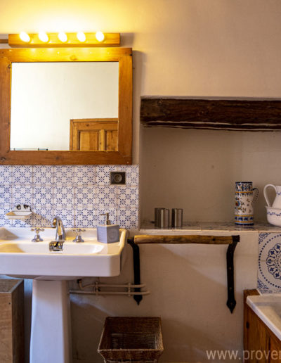Le charme de la salle de bain avec sa faience provençale et les éléments en bois pour une atmosphère chaleureuse dans la location de vacances La Norgère à Mane en Provence