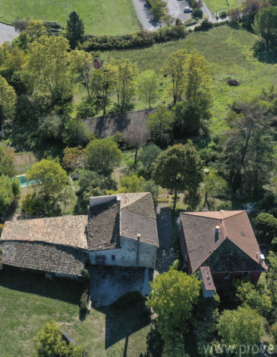 Vue du dessus sur le grand jardin arboré et verdoyant avec la piscine et la dépendance abritant une salle de jeux de la location de vacances La Norgère située au coeur de la Provence à Mane