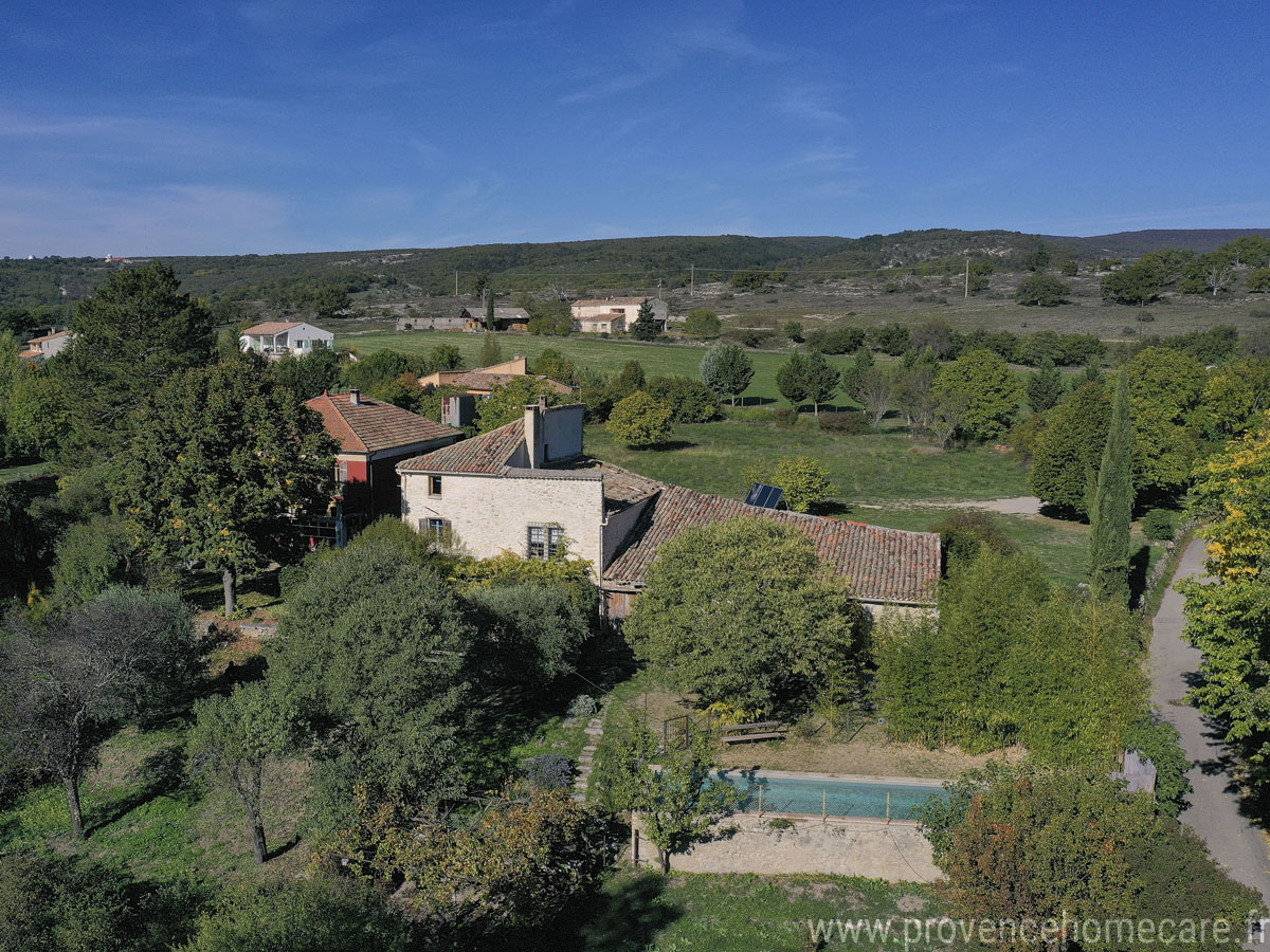 Vue du ciel de la façade avant avec le jardin arboré, ombragé et la piscine privée de ce joli gîte de vacances à louer au coeur de la Provence, à Mane.