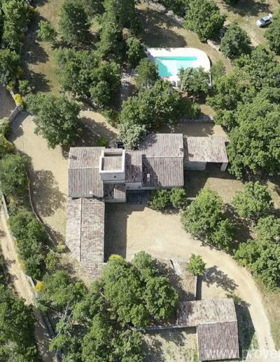 Vue aérienne de la bâtisse en pierre dans son écrin de verdure et sa piscine à l'eau cristalline.Des séjours qui rime avec évasion et plénitude dans la location de vacances La Poncette à Reillanne au coeur du Lubéron