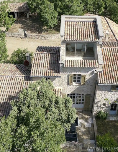 Vue du dessus de la façade avant avec le pigeonnier et sa terrasse dominante offrant un point de vue panoramique sur le Luberon, atout charme de la location de vacances La Poncette, située à Reillanne.