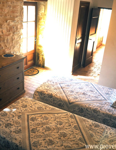 La chambre au rez de chaussée ou le charme et le confort s'allient par des tons neutres et reposants, la pierre, la tomette et le bois tout en harmonie, dans la location de vacances La Poncette située à Reillanne dans le Luberon.