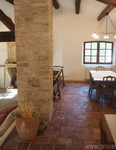 L'espace séjour ouvert avec la salle à manger et son mobilier romantique en bois et le salon en contrebas de quelques marches avec son mobilier confortable se situe au rez-de-chaussée de la location de vacances La Poncette à Reillanne dans le Luberon