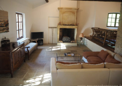 Salon avec banquette, canapé d'angle, télévision, cheminée, maison gérée par l'agence Provence Home care