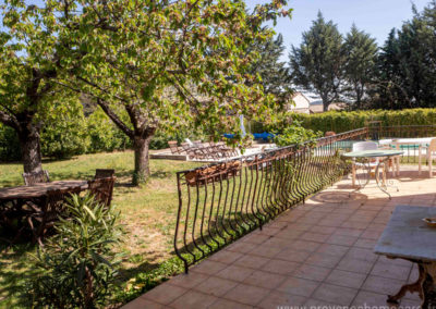Terrasse, table et chaises de jardin, arbres, vue sur la piscine
