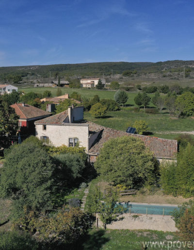Vue du ciel de la façade avant avec le jardin arboré, ombragé et la piscine privée de ce joli gîte de vacances à louer au coeur de la Provence, à Mane.