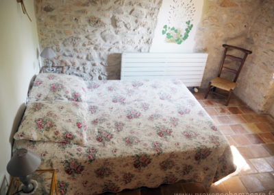 Chambre avec grand lit double, chevets, murs en pierres, à l'etage, maison gérée par l'agence Provence Home care