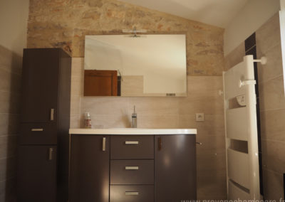 Salle de bain de la suite parentale, à l'étage, pierres apparentes, meuble design, miroir et chauffe-serviettes, maison gérée par l'agence Provence Home care