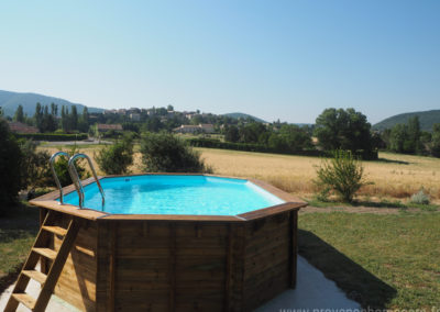 Vue piscine avec en fond le village médiéval de Dauphin dans le Luberon, maison gérée par l'agence Provence Home care